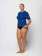 Woman wearing a blue and black patterned swimsuit on a white background