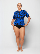 Woman wearing a blue and black patterned swimsuit on a white background