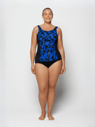 Woman wearing a black and blue patterned swimsuit on a white background