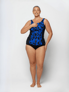 Woman wearing a black and blue patterned swimsuit on a white background