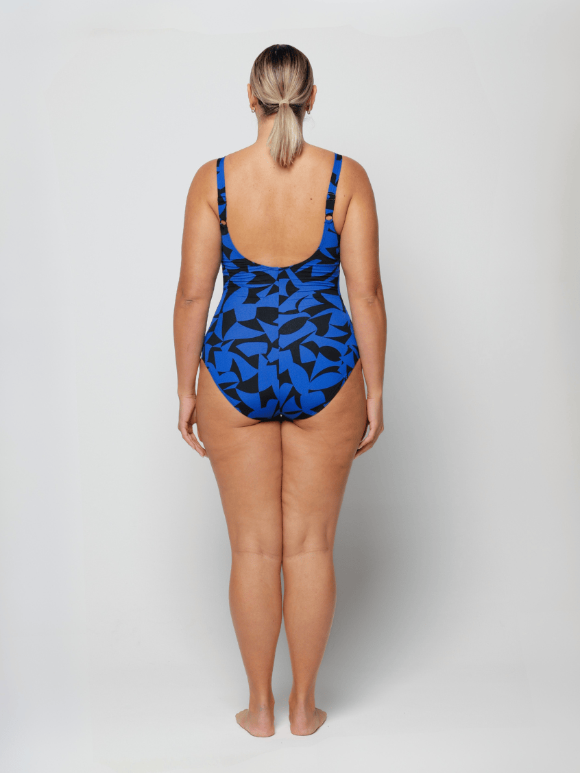 Woman wearing a blue and black patterned swimsuit on a white background