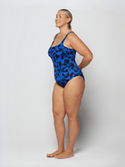 Woman wearing a blue patterned swimsuit on a white background