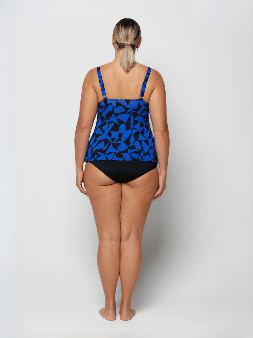Woman wearing a blue and black patterned tankini on a white background