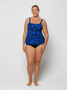 Woman wearing a blue and black patterned swimsuit on a white background