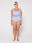 Woman wearing a light blue bikini set on a white background