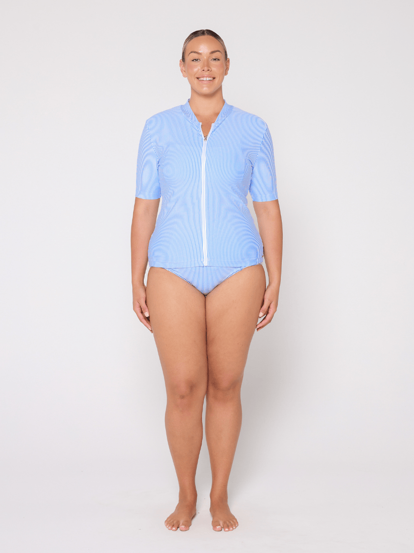 Woman wearing a light blue swimsuit with a zipper on a white background
