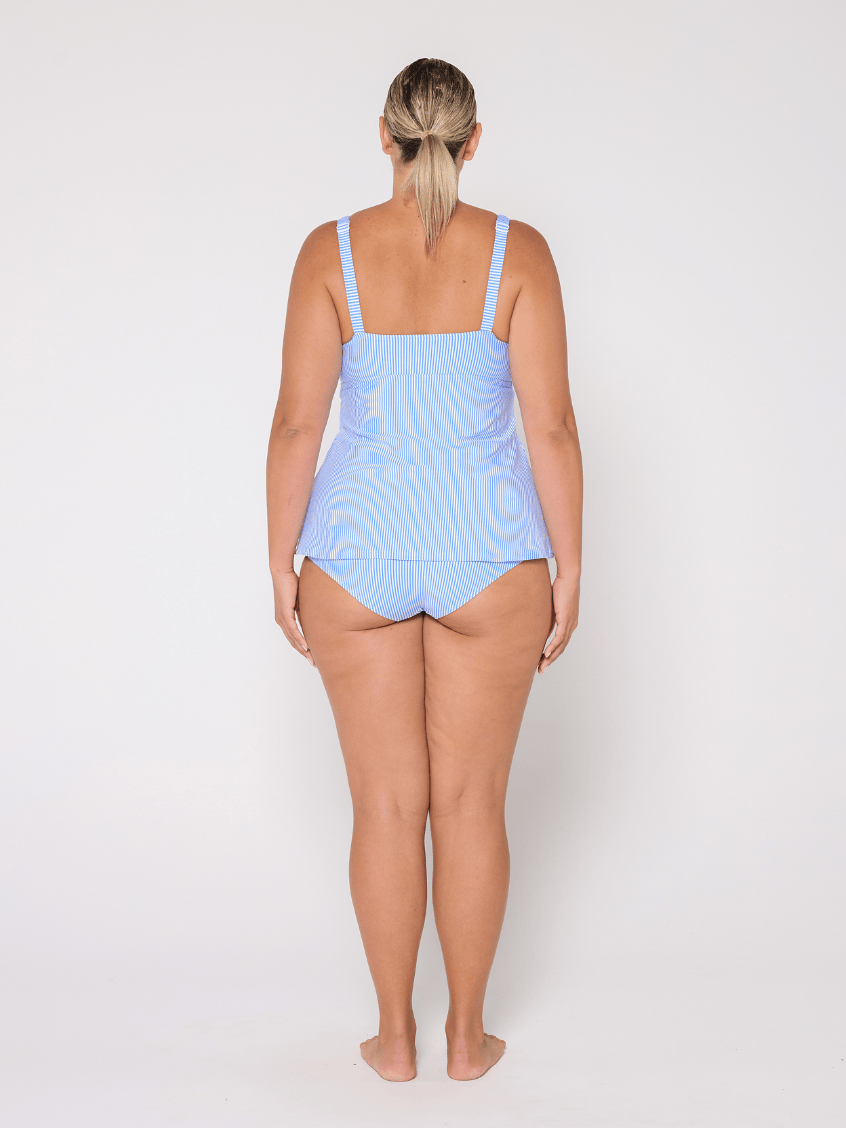 Woman wearing a light blue tankini top on a white background