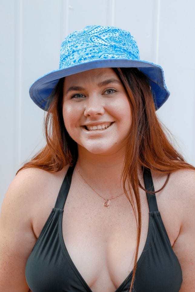 woman wears a blue and white paisley printed bucket hat suitable for swimming