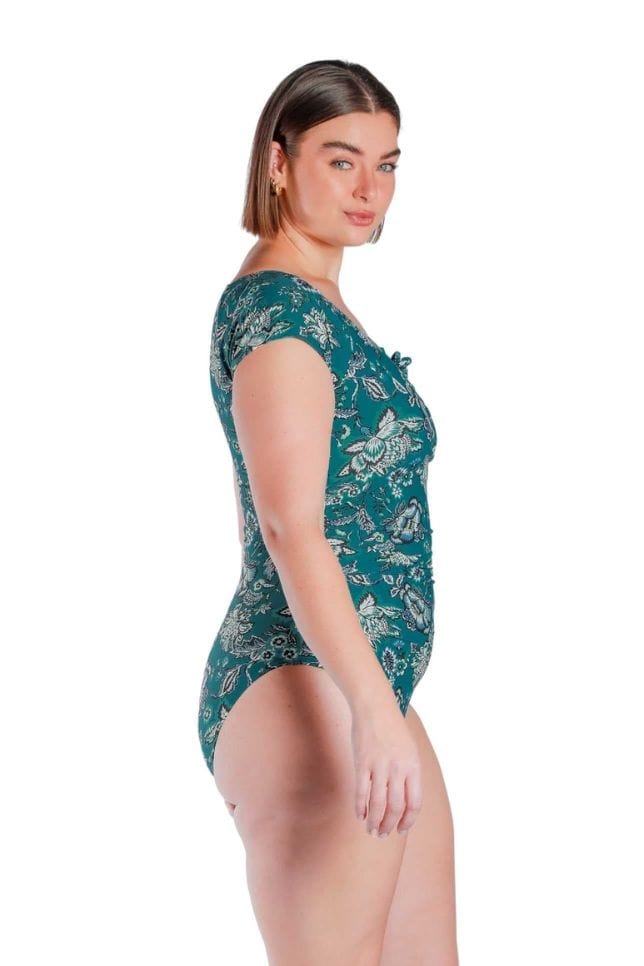 Side shot of model wearing Sardinia teal hues floral printed tie front one piece 