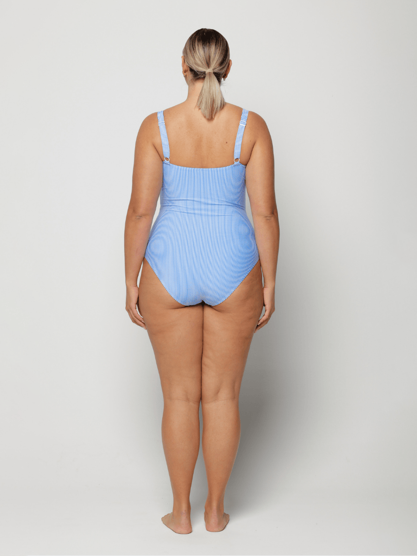 Woman wearing a blue square neck swimsuit on a white background with adjustable straps