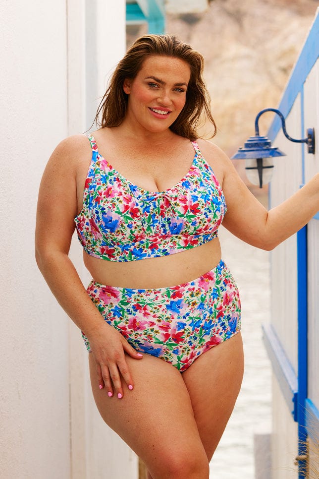 Brunette model wears bright floral bikini top and bottom
