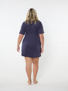 Person wearing a navy blue dress against a white background