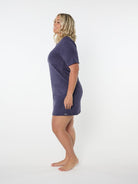 Woman wearing a navy blue t-shirt dress on a white background