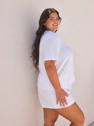Woman wearing a white t-shirt against a plain background