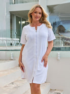 Model wearing a zip through terry towelling dress in white