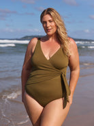 Woman wearing a green swimsuit on a beach