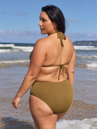 Brunette model wears tie neck bikini top in olive textured fabric