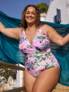 Close up image of brunette model wearing  v neck one piece with tie detail