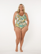 Woman wearing a floral one-piece swimsuit on a white background