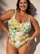 Woman wearing a colorful floral swimsuit against a neutral background