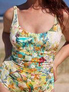 Woman wearing a colorful floral swimsuit on a beach.
