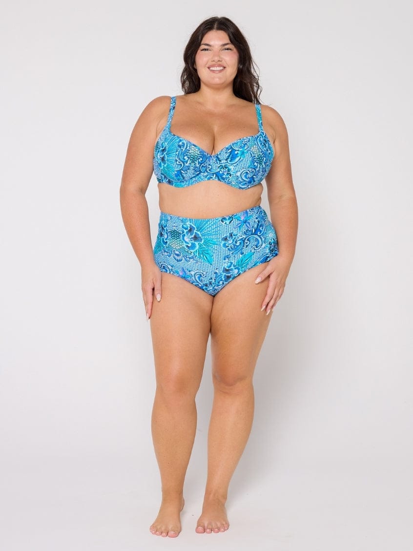 Woman wearing a blue patterned bikini set on a white background