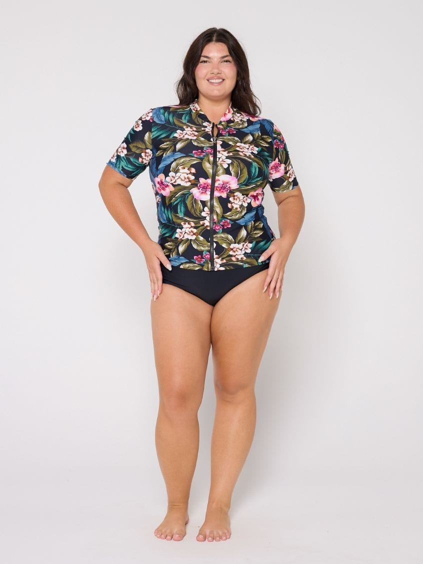 Model in studio wearing a floral short sleeve rash vest with full zip