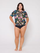 Model in studio wearing a floral short sleeve rash vest with full zip