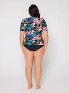 Model in studio wearing a floral short sleeve rash vest with zip front detail