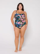 Woman in studio wearing a floral swimsuit on a white background
