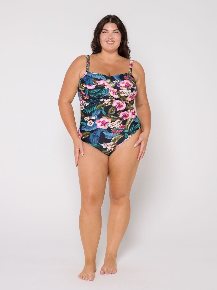 Woman in studio wearing a floral swimsuit on a white background