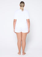 Person wearing a white t-shirt and shorts set on a plain background