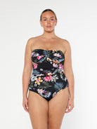 Blonde model wears black floral strapless one piece in chlorine resistant fabric
