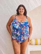 Brunette model wears figure flattering blue floral tankini with 3 tier design for tummy control