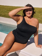 Woman in a black swimsuit by a pool