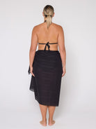 Person wearing a black sarong on a white background