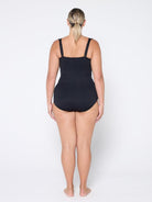 Person wearing a black swimsuit on a white background