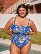 Brunette model shows supportive bandeau one piece with removable straps in blue floral print