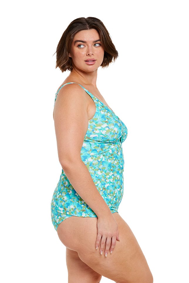 Brunette model showing side of blue and green floral tankini