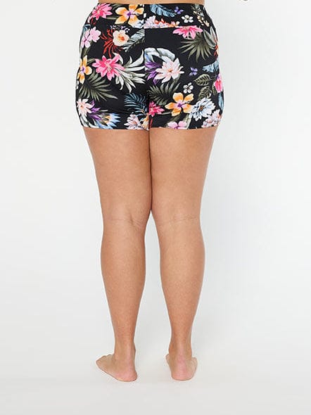 Woman wearing a black floral high-waisted bikini bottom on a white background