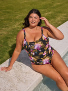 Brunette model wears flattering scoop neck chlorine resistant one piece in pink and gold florals
