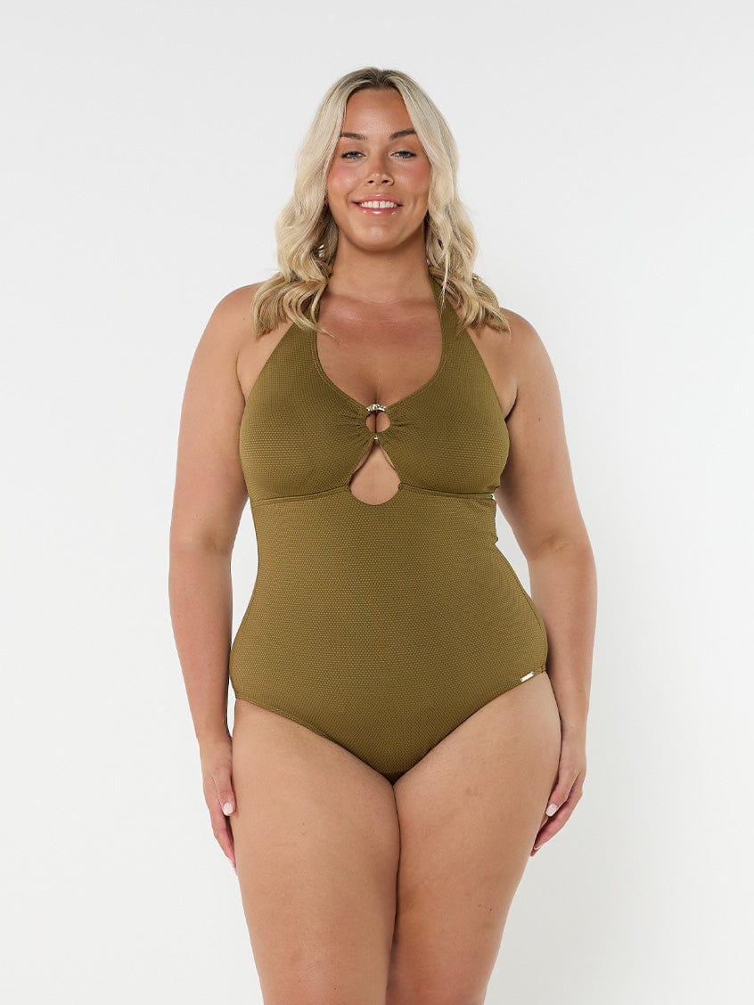 Blonde model wears flattering adjustable halter neck one piece in textured khaki fabric 