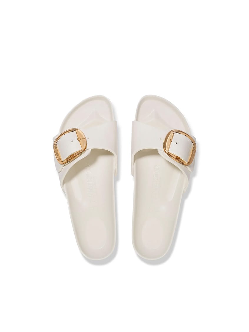 A pair of off-white slide sandals with double straps and gold-tone square buckles, shown from a top-down view on a white background.
