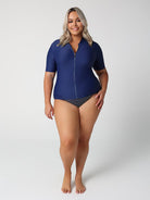 Woman wearing a blue swimsuit with a white background