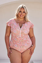 Blonde model wearing blush pink floral frill sleeve one piece