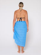 Woman wearing a blue striped towel around her waist on a white background