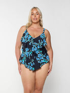Blonde model shows front of blue floral swimsuit top with 3 ruffles