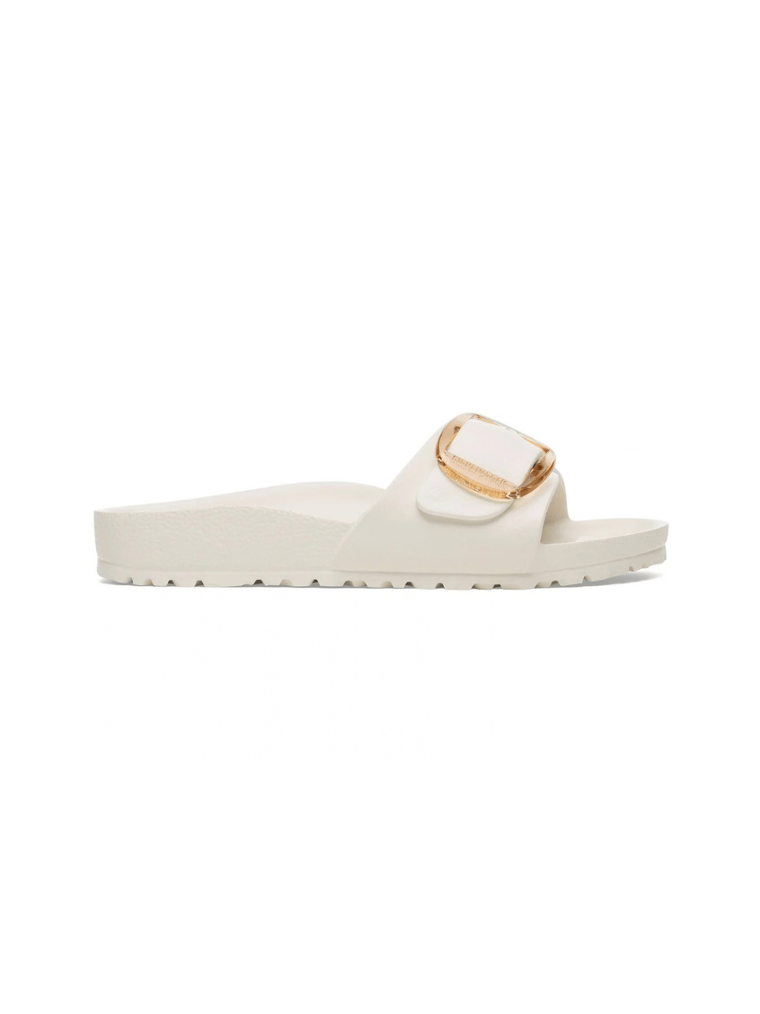 White slide sandal with a gold buckle on a white background