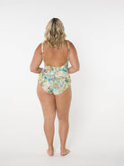 Woman wearing a floral high-waisted swimsuit on a white background