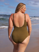Woman wearing an olive green swimsuit on a beach
